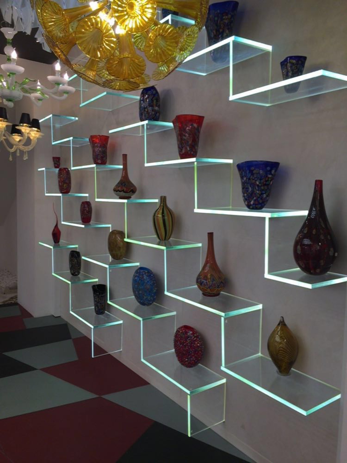 Edge-lit glass shelving carrying a glass collection