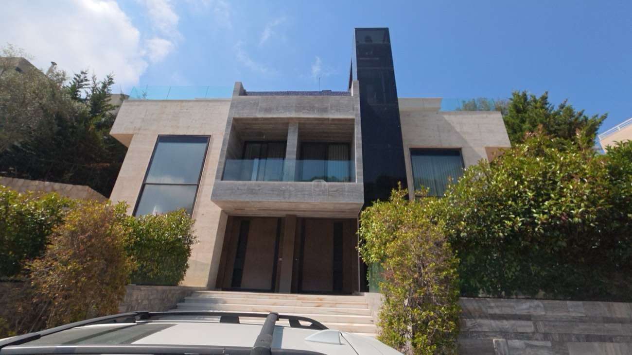 House elevation in travertine with black glazed volumes