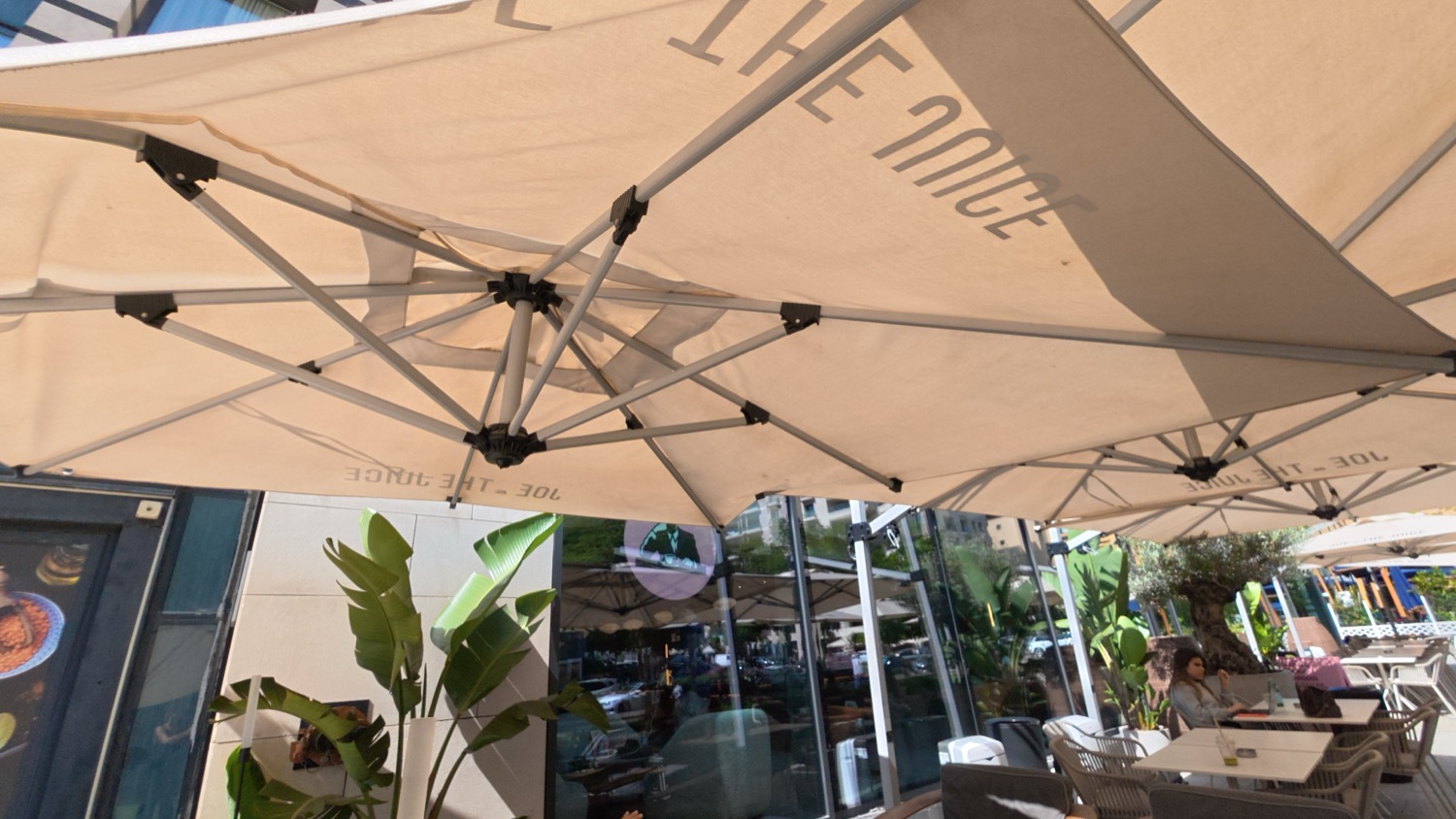 Under the parasols, against the glazing