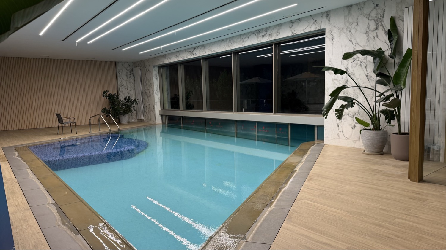 The indoor pool behind full-height glazing