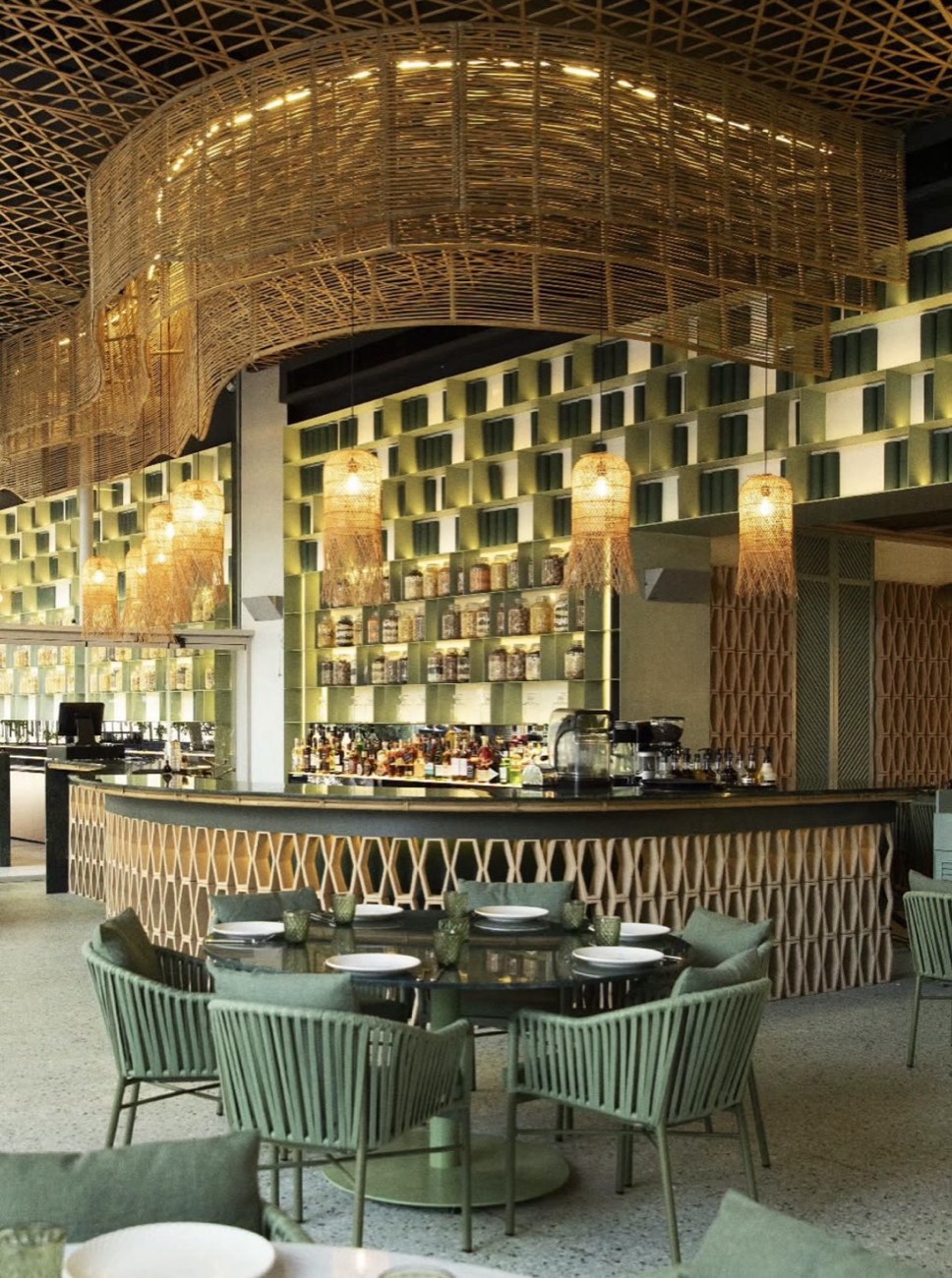 Restaurant bar beneath a woven ceiling, glazed to the garden
