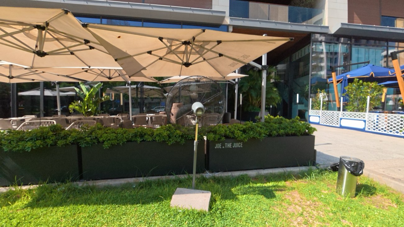 Terrace enclosed with glazed screens under parasols